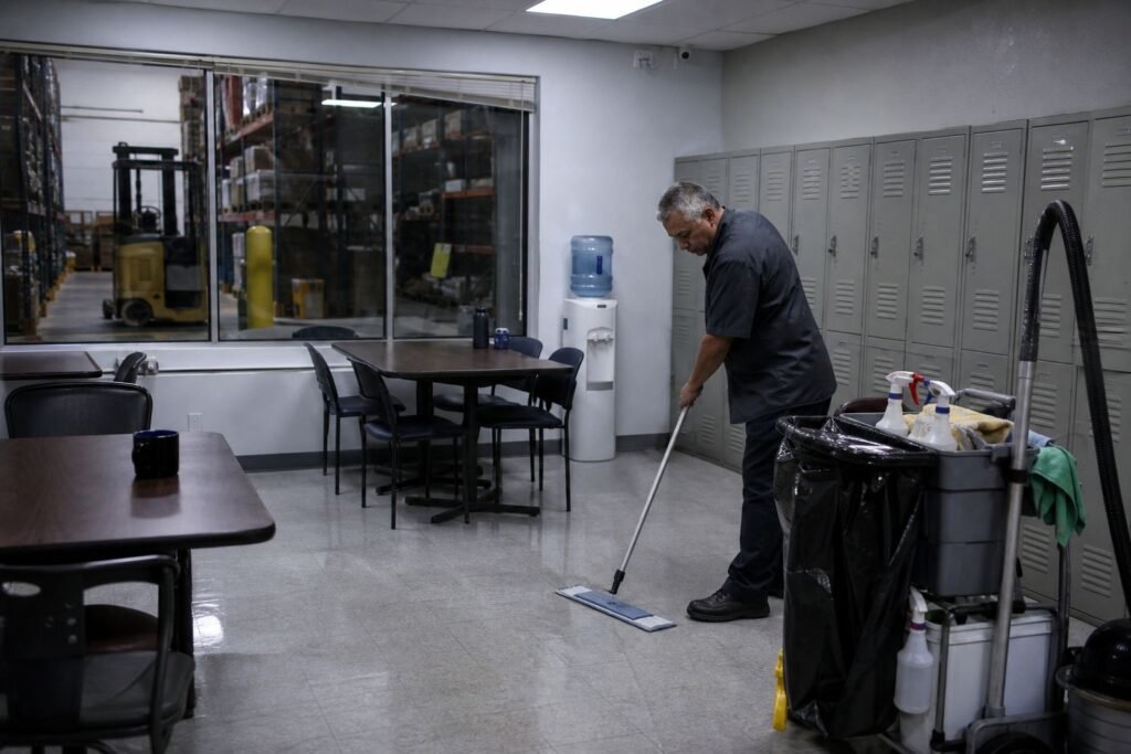 Cleaner mopping a warehouse break room floor